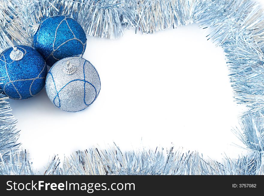 Three blue and silver Christmas baubles with silver tinsel forming a frame on white backgound. Three blue and silver Christmas baubles with silver tinsel forming a frame on white backgound