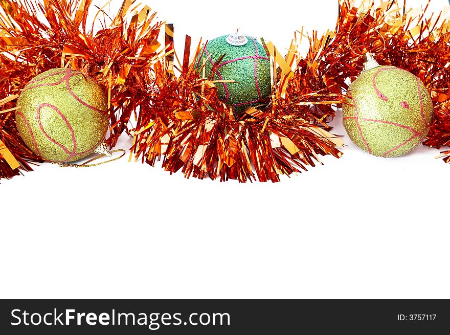 Three Christmas baubles with bright orange tinsel