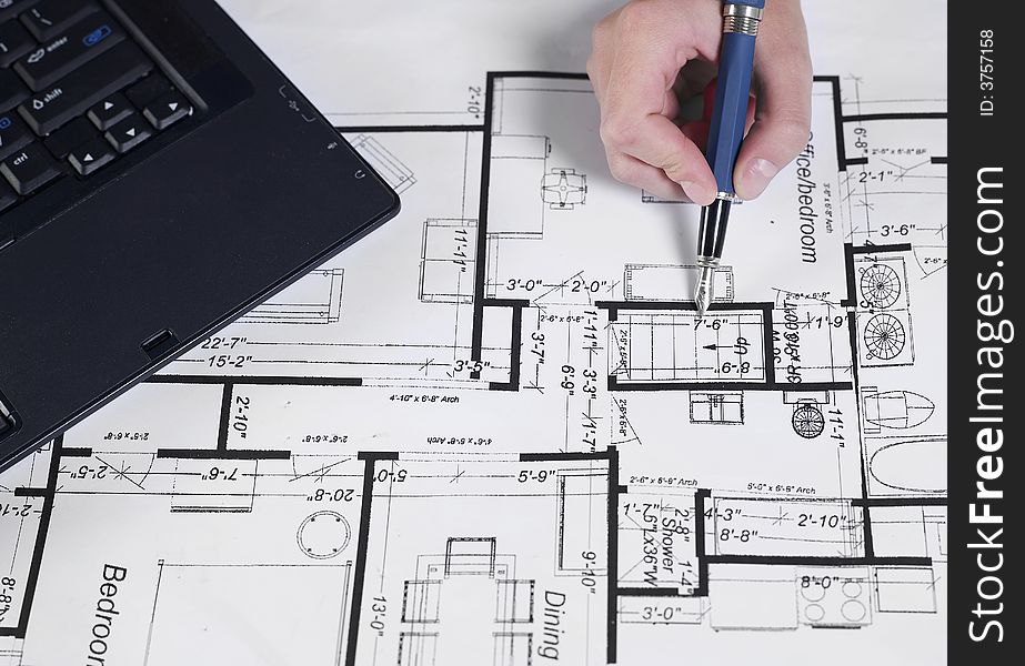 Engineer working on blueprints with pen. Engineer working on blueprints with pen