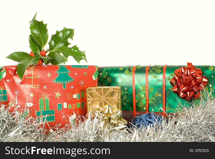 Christmas gifts, presents, wrapped with decorative stars and ribbons, ilex,holly on top of it. Christmas gifts, presents, wrapped with decorative stars and ribbons, ilex,holly on top of it