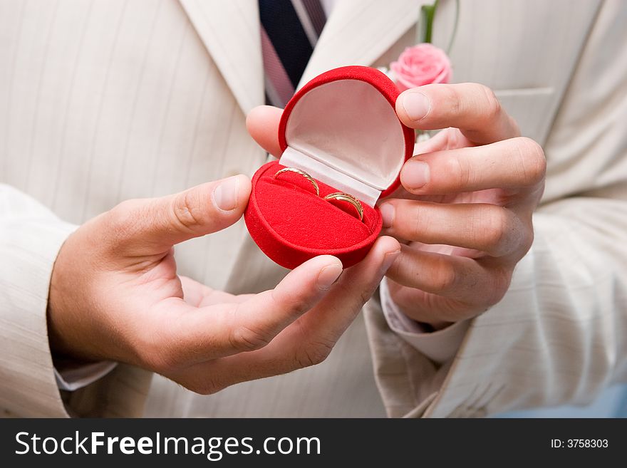 Man holds in hands a box with golden rings. Man holds in hands a box with golden rings