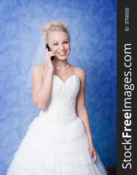 Smiling bride calling by phone