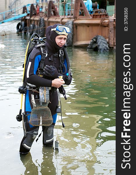 Scuba diver in wet suit entering the cold water. Scuba diver in wet suit entering the cold water