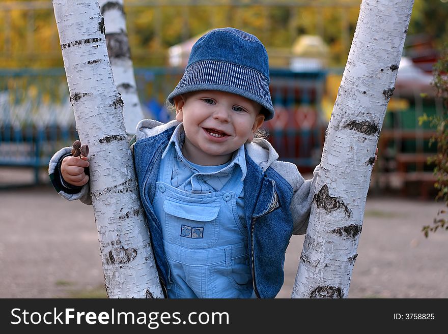 Smiling little boy standing between two trees