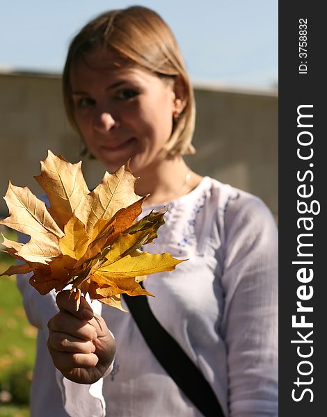 Girl Holding Out Yellow Leaves