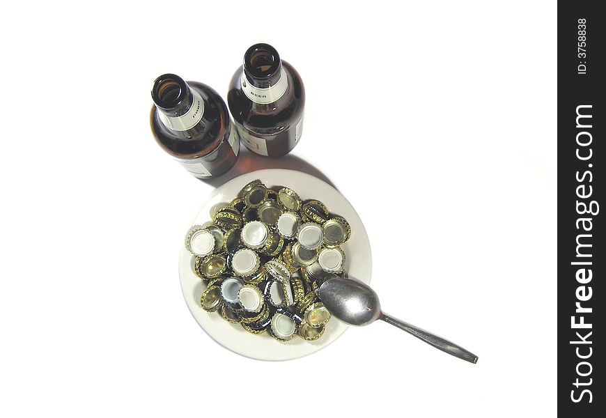 Beer bottles, plate with stoppers and the spoon on a white background. Beer bottles, plate with stoppers and the spoon on a white background