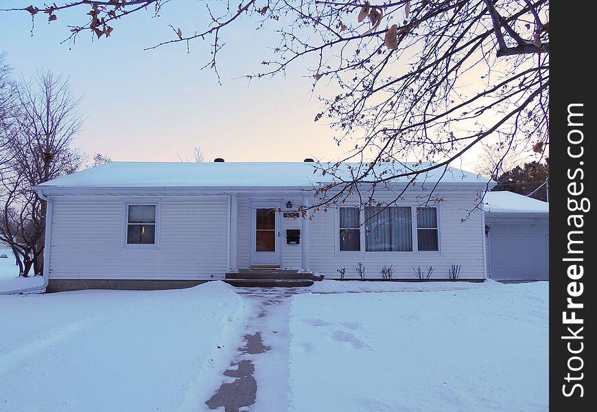 A generic type white ranch home in the winter. For use for exterior maintenance and cleaning service or snow removal and lawn care. Home is attractive, but in need of a pressure wash to look its best. This could also serve for real estate or insurance advertising. Picture was taken at sunset in soft light. A generic type white ranch home in the winter. For use for exterior maintenance and cleaning service or snow removal and lawn care. Home is attractive, but in need of a pressure wash to look its best. This could also serve for real estate or insurance advertising. Picture was taken at sunset in soft light.