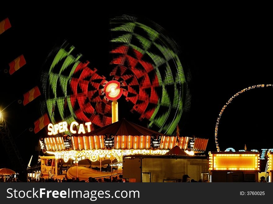 A colorful amusement ride at night with colorful lights.