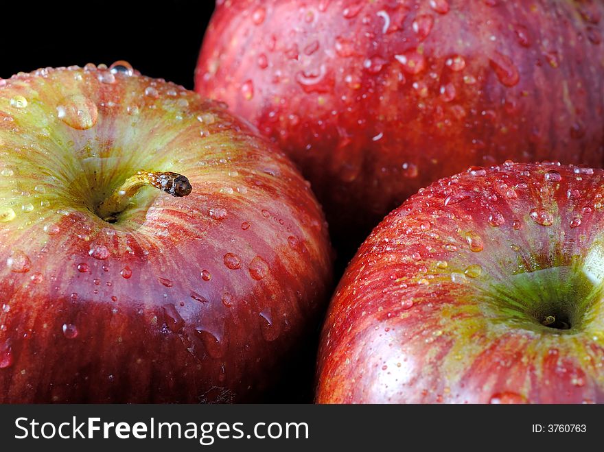 Closeup on three fresh red apples with water drops
