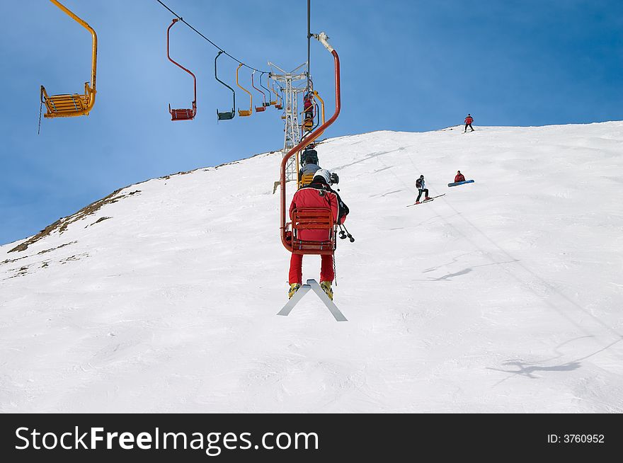 Skiers on chair lift in the winter mountains