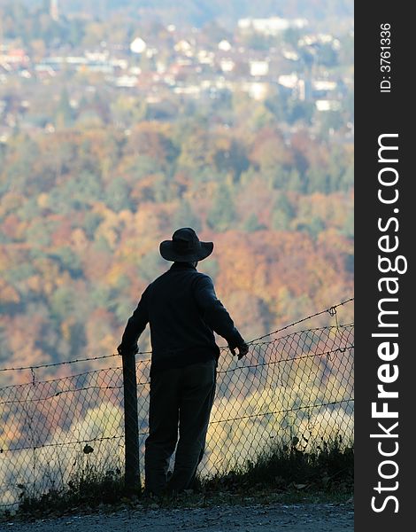 Silhouette of a man contemplating a forest and encroaching development, in Fall. Silhouette of a man contemplating a forest and encroaching development, in Fall.