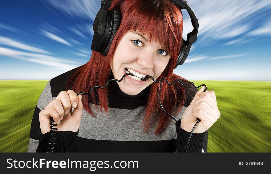 Cute girl with red hair biting the cord of her headphones while listening to music.

Studio shot. Cute girl with red hair biting the cord of her headphones while listening to music.

Studio shot.