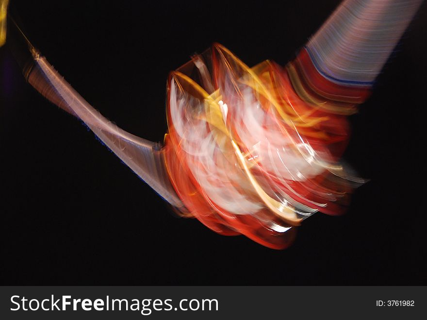 Long exposure of fairground ride traveling at stomach-churning speed; metaphor for mental turmoil or disturbance