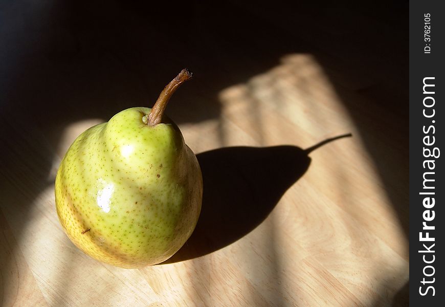 Green pear close-up shot with sunlight and shadow