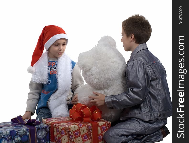 The boy in a cap santa with gifts for friend on a white background. Isolated. Studio. The boy in a cap santa with gifts for friend on a white background. Isolated. Studio.