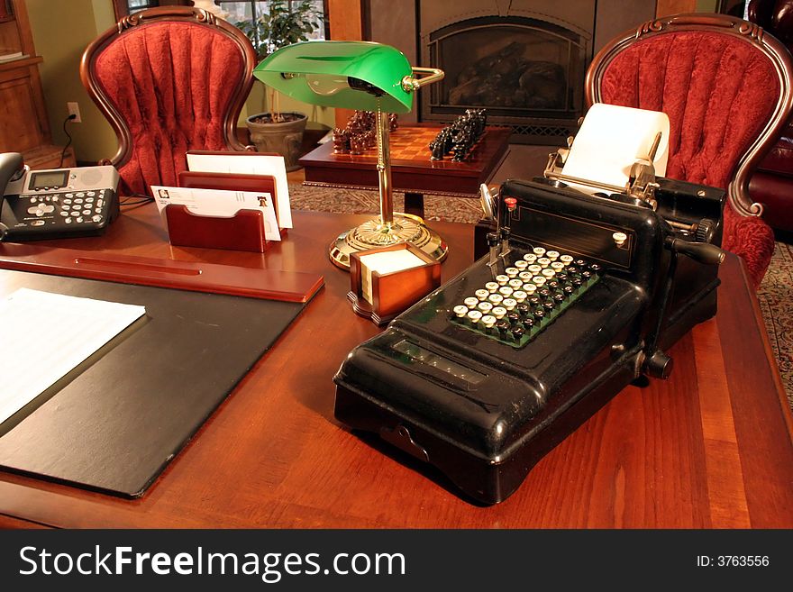 This is an image of an antique adding machine in a home office.