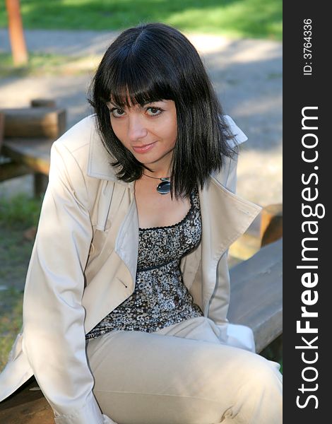 Beautiful woman sitting at the bench in the park. Beautiful woman sitting at the bench in the park