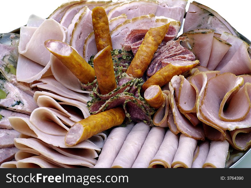 Plate of sliced ham, sausage and salami with herbs
