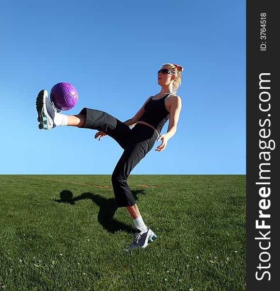 Young woman exercising with the ball in a park