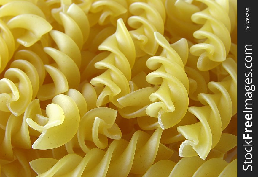 Scattered spiral pasta close-up background