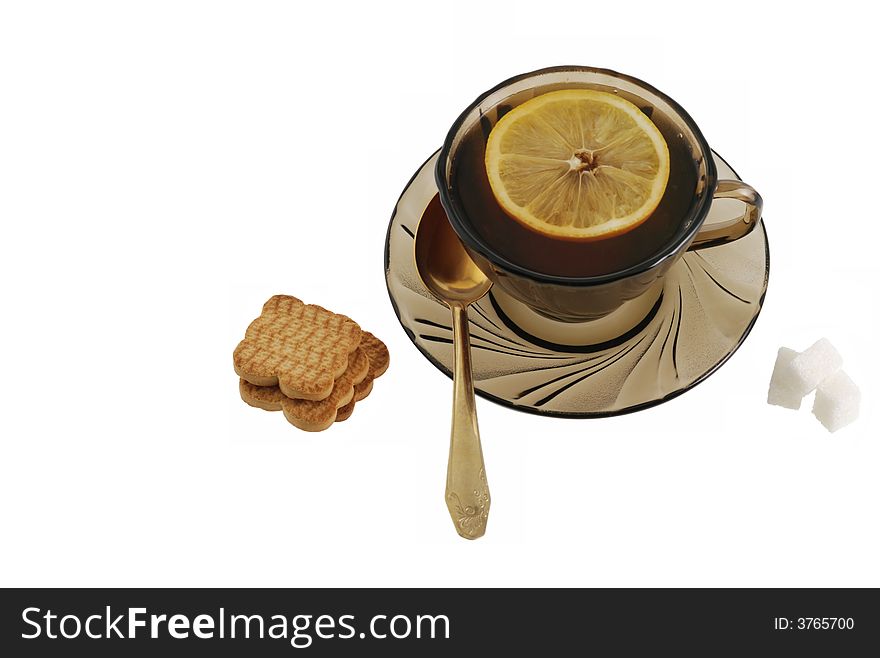 Tea. A cup with tea, cookies, sugar, a lemon.