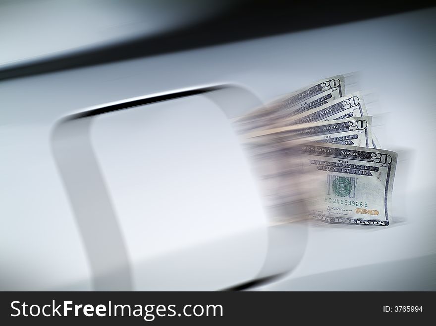 Motion blur of money spilling from a fuel filler door while car is in motion. Motion blur of money spilling from a fuel filler door while car is in motion.