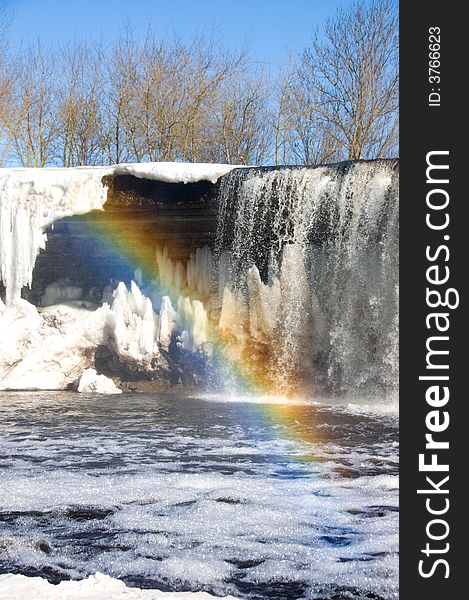 Rainbow over iced waterfall