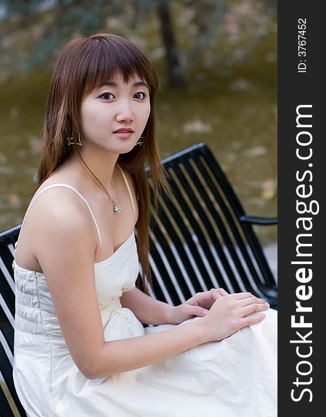 A girl with eyes of hope sitting on campus in deep autumn