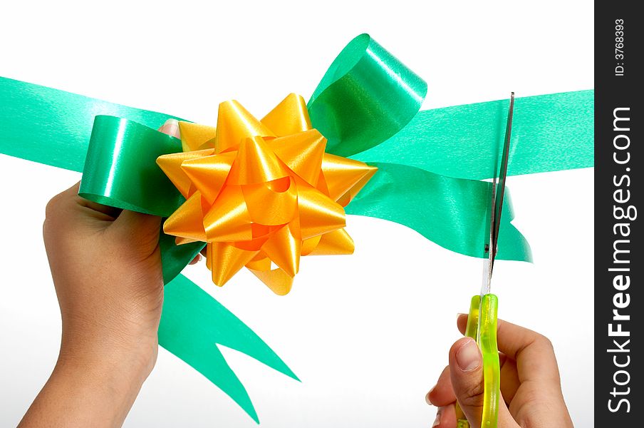 Hands cutting a green ribbon with scissors. Hands cutting a green ribbon with scissors
