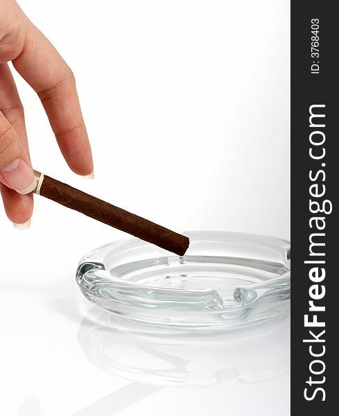 A hand holding a cigar over a white background