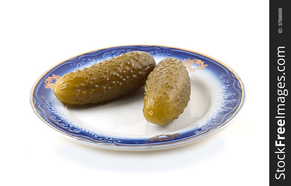 Pickled cucumbers on a plate isolated on white