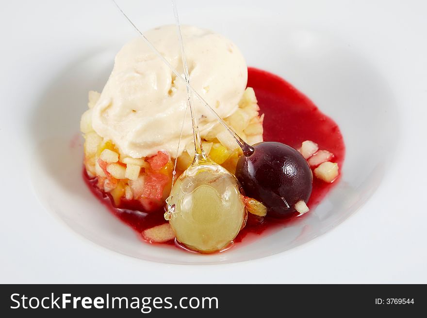 Dessert of ice cream and fruits covered with syrup