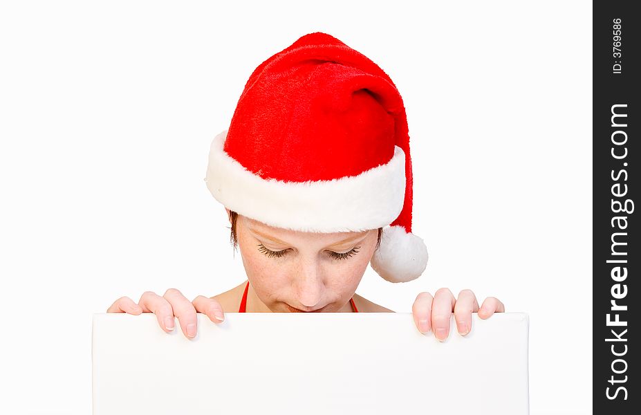 Beautiful girl in christmas bikini and with christmas hat is holding up a white sign for copy space. With background clipping path for your convenience. Beautiful girl in christmas bikini and with christmas hat is holding up a white sign for copy space. With background clipping path for your convenience