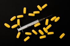 Yellow Pills And Syringe Stock Image