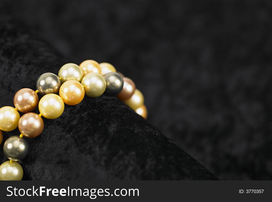 A string of beautiful pearls on a crushed velvet background. A string of beautiful pearls on a crushed velvet background.