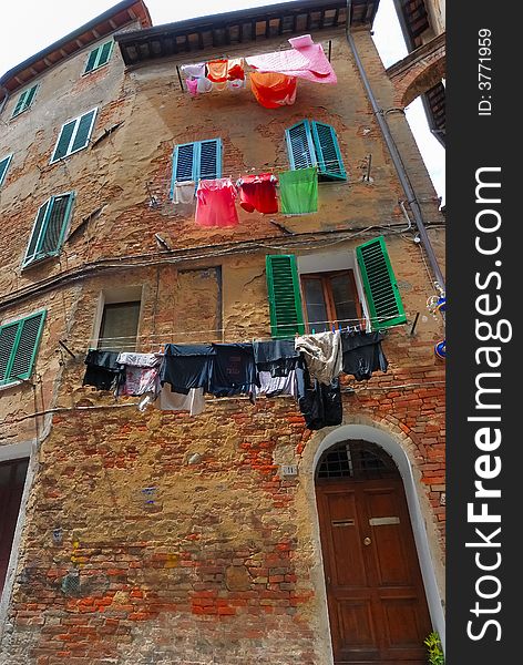 Facade of an historic building in Siena with washing for drying. Facade of an historic building in Siena with washing for drying