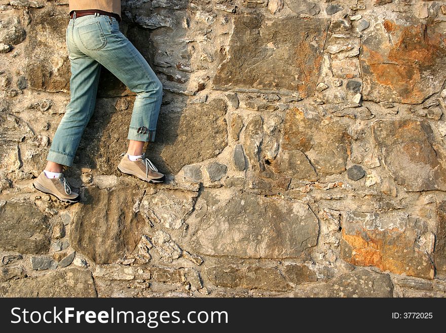 Detail from woman climbing textured granite wall