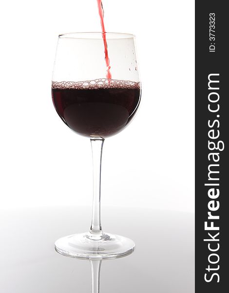 Red wine pouring down on white background