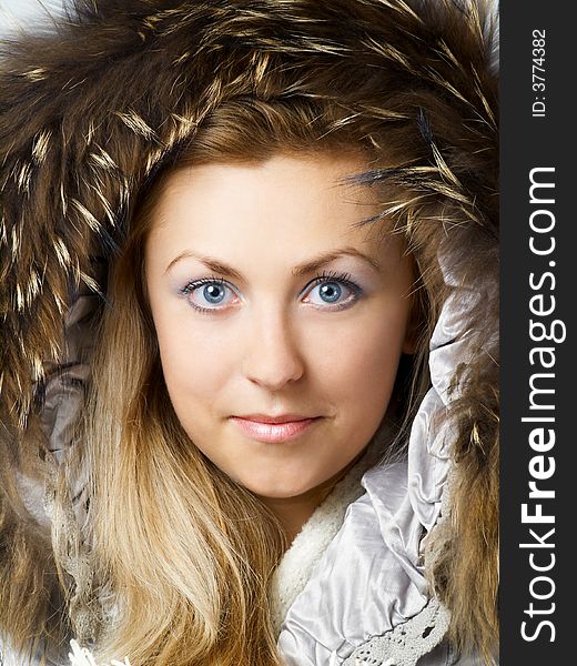 Beautiful blonde girl in fur hood looking straight