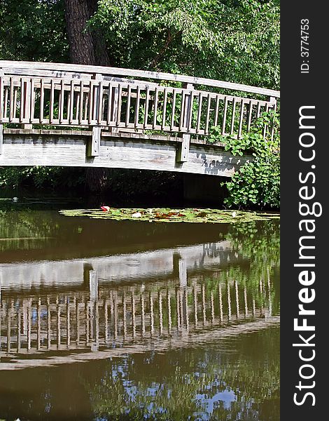 Reflection of wooden bridge in pond. Reflection of wooden bridge in pond