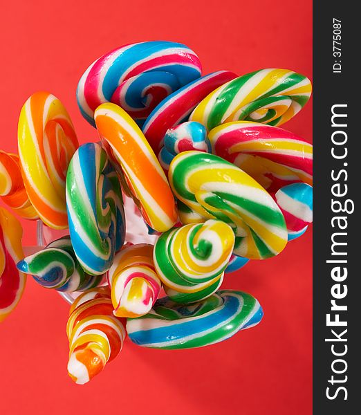 Twirl lollipop candies over a red background