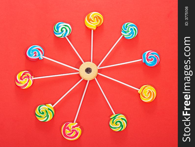 Twirl lollipop candies over a red background