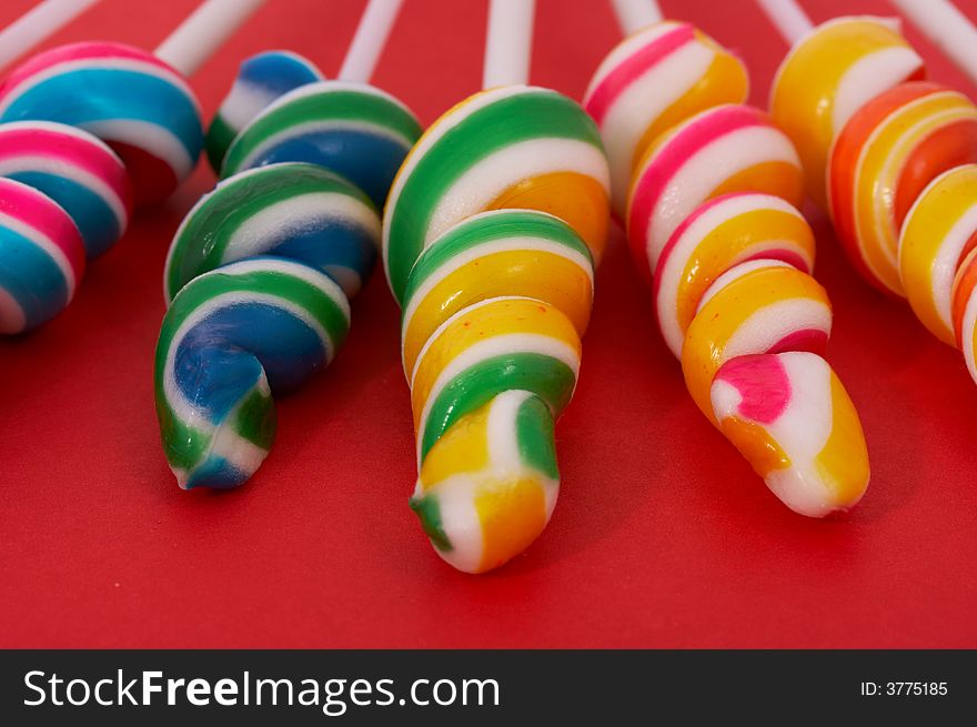 Twirl lollipop candies over a red background