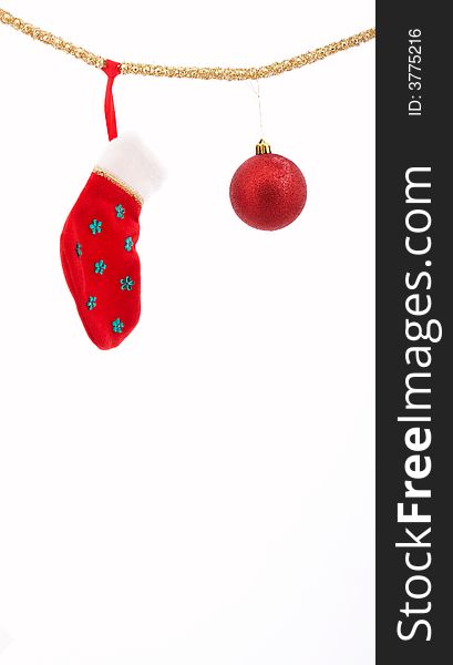 A christmas stocking and a bauble hanging over a white background