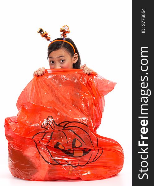 A young girl peeping from a halloween lawn bag. A young girl peeping from a halloween lawn bag