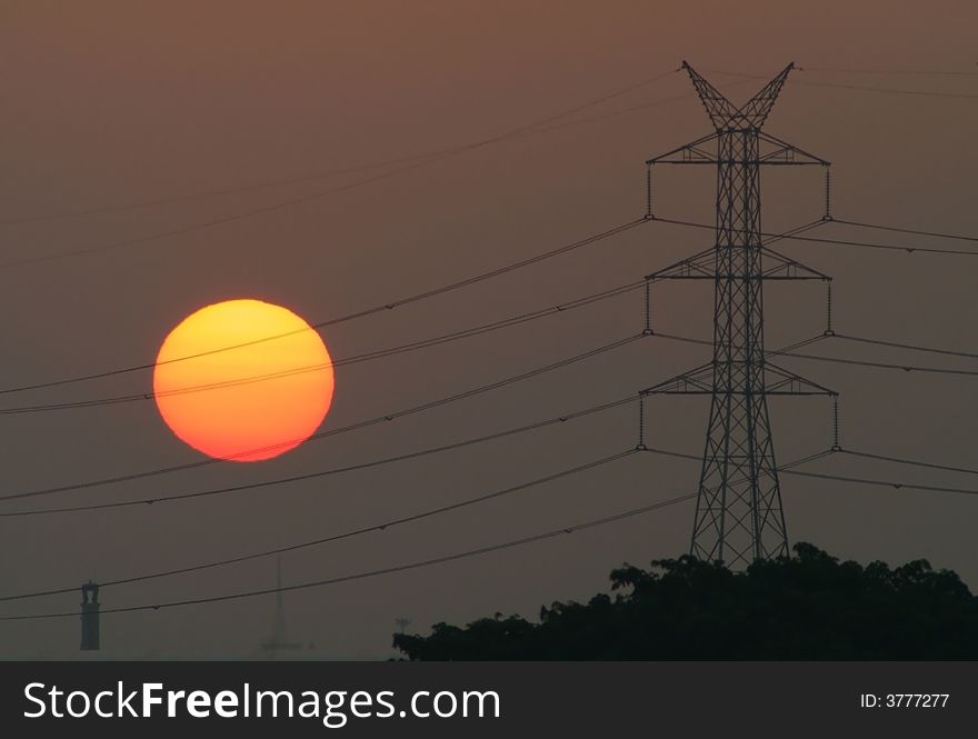 Sunrise over an industrial estate with silhouettes of a power line. Sunrise over an industrial estate with silhouettes of a power line.