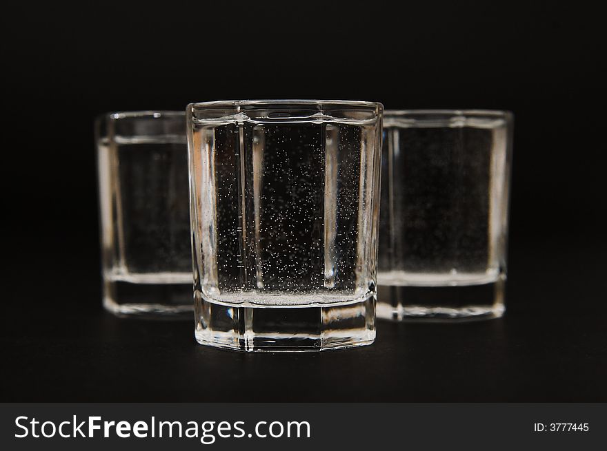 Vodka glasses over black background