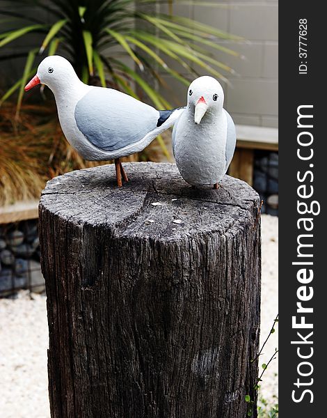 Bird statues sitting on a wooden block.