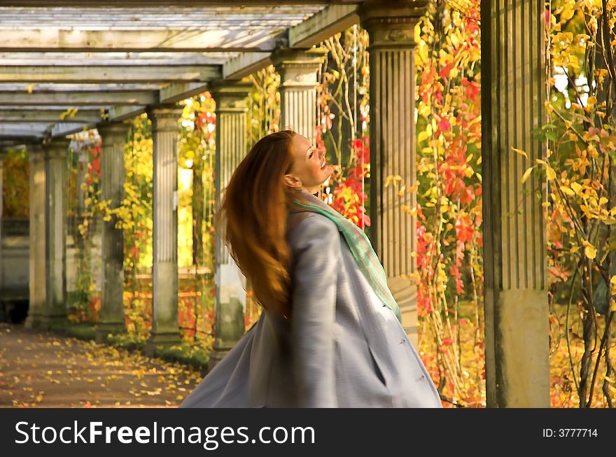 The cheerful beautiful girl in autumn park