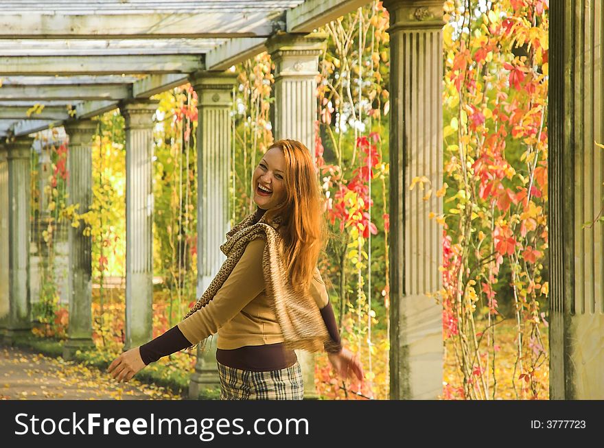 The cheerful beautiful girl in autumn park